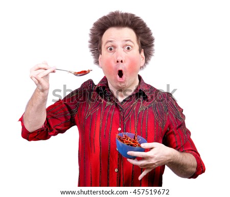 Man holding a spicy red paprika isolated on white background. Man is shocked when eating chili peppers. Stock foto © 