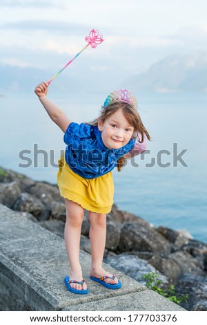 Lovely little girl playing outdoors, pretending a princess