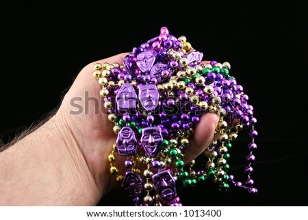 Hand with Mardi Gras beads.