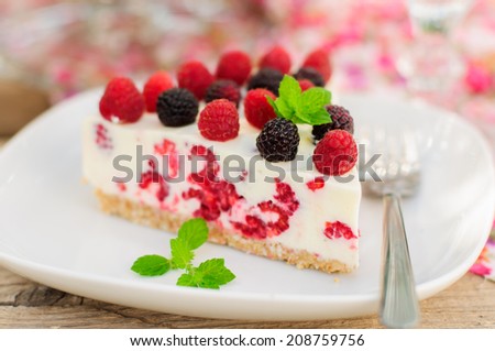 A Piece of No-bake Fresh Raspberry Cheesecake with Red and Black Raspberries and Melissa, Summer Cake
