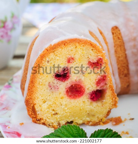 Summer Lemon and Caraway Seed Bundt Cake with Raspberries Topped with Sugar Glaze, close up, square