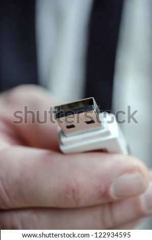 Closeup of a male hand holding usb key towards you.