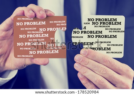 Retro image of businessman holding two puzzle pieces with the words No Problem repeated many times as he shows that he has found the solution and answer enabling him to fit the pieces together.