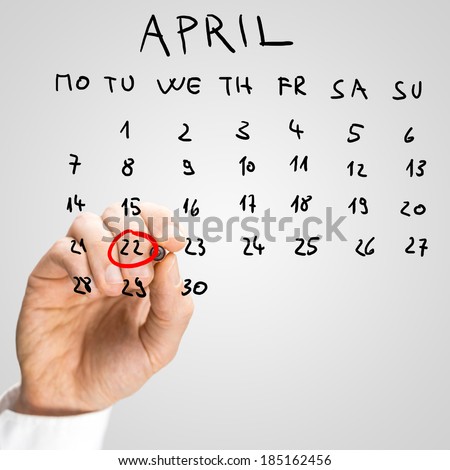 Male hand encircling the date of April 22 on a monthly calendar placed on a virtual screen, in order to remember to celebrate International Mother Earth Day.