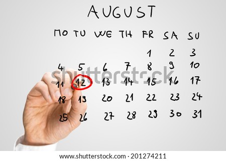 Male hand marking August 12th - International youth day - on virtual calendar.