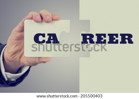 Businessman holding two matching puzzle pieces with the word - Career - spread over them in a concept of achievement, challenge, solution and success.