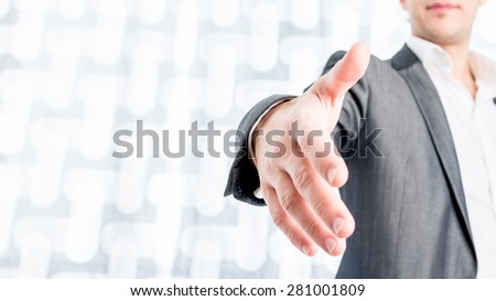 Close up Young Businessman in Black Suit Showing Handshake Gesture at the Camera On Abstract White Background.