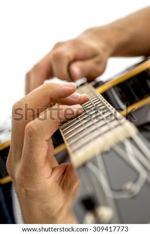 Closeup of male guitarist playing black jazz electric guitar. Isolated over white background.