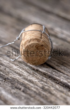 Champagne cork lying on textured rustic wooden boards.