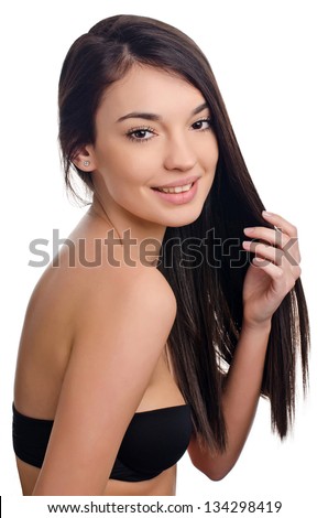 Beautiful brunette girl with long hair. Beauty portrait. Young attractive brunette woman holding her long hair.