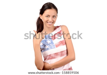 Beautiful American girl signing thumbs up. Attractive girl with USA flag on her blouse. Isolated on white.