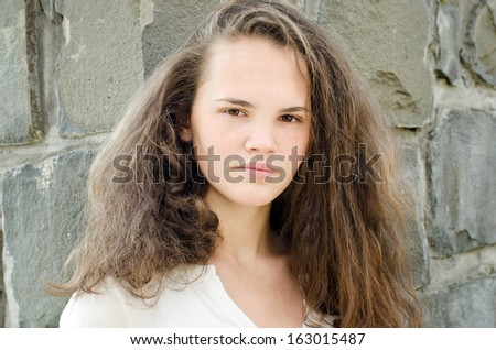 Portrait of a beautiful young freckled girl. Young teenage girl with a unique face with freckles. Outdoors.