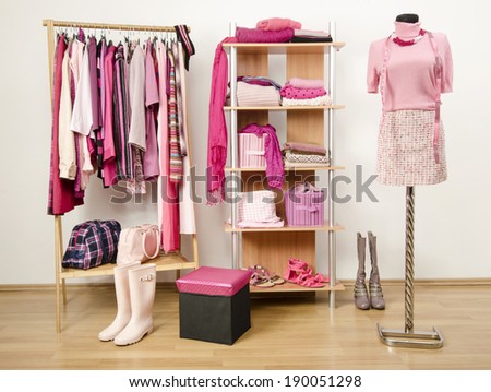 Dressing closet with pink clothes arranged on hangers and shelf, outfit on a mannequin.  Wardrobe full of all shades of pink clothes, shoes and accessories.