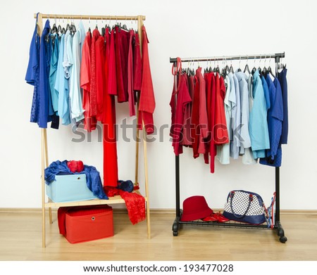 Wardrobe with red and blue clothes hanging on a rack nicely arranged. Color coordinated clothes on hangers in a dressing room.