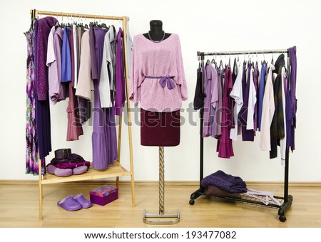 Wardrobe with purple clothes arranged on hangers and an outfit on a mannequin. Dressing closet with all shades of violet clothes, shoes and accessories.