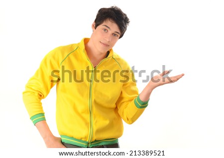 Happy man showing to the side. Attractive guy with yellow sport blouse presenting. Isolated on white.