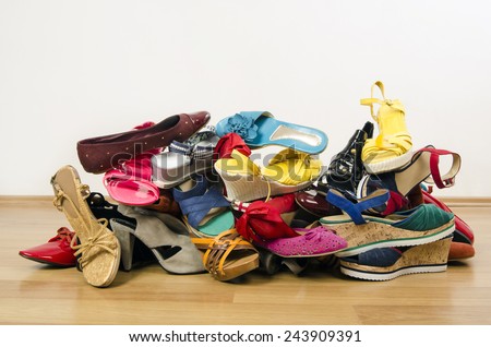 Big pile of colorful woman shoes. Untidy stack of shoes thrown on the ground.