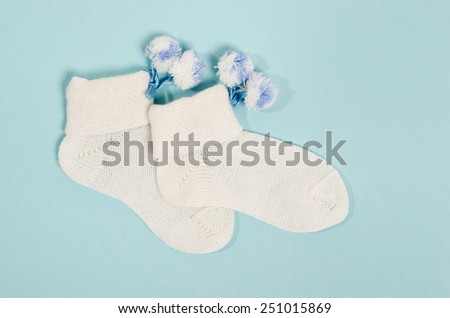 Cute little baby boy socks. Small white socks on blue background.