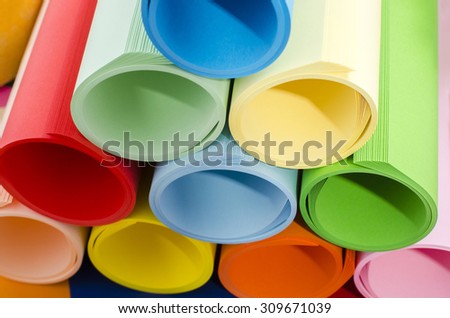 Color paper rolled and piled. Roles of color paper in a stack.