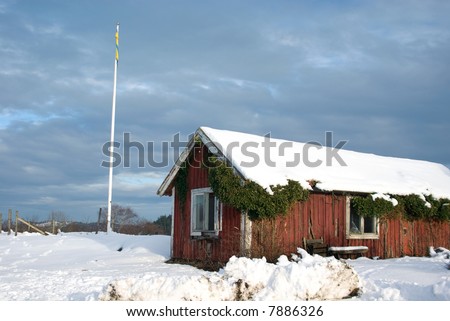 traditional swedish red cottage in snow