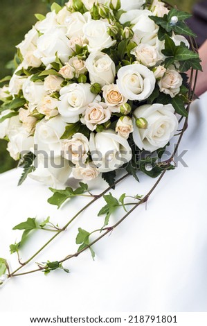 close up picture of a bridal bouquet with white roses and ivy
