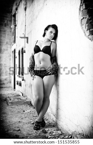 Beautiful brunette in a black underwear and jacket posing in a old building, black and white photo, glamour photography