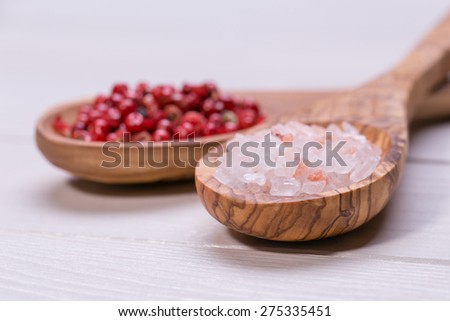 himalayan salt and red grain of pepper on wooden spoons