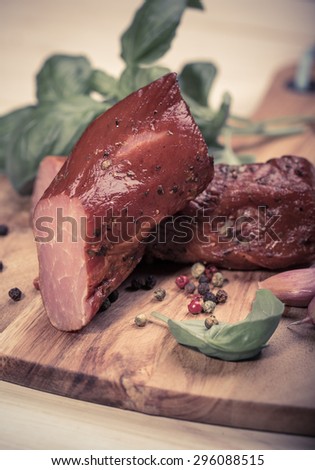 Natural prepared slow food. Smoked pork sirloin with herbs and spices on wooden board. Traditional Polish cold meats