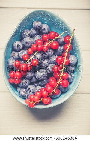 red currant and blue berries in blue bowl