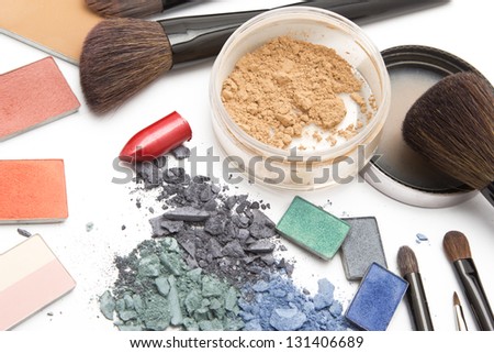 Eye shadow, lipstick, powder, blush and brushes on makeup artist table