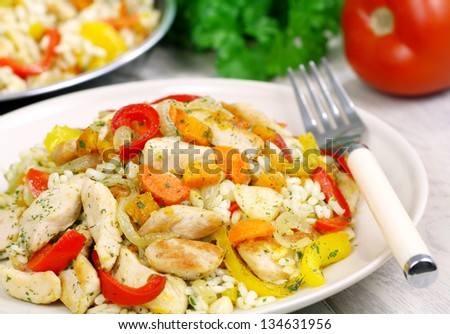 Risotto with chicken and vegetables on a wooden table