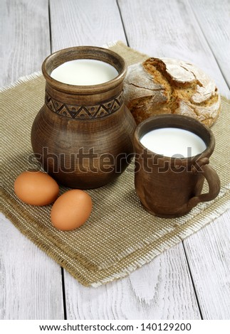 Milk, eggs and bread on a wooden table