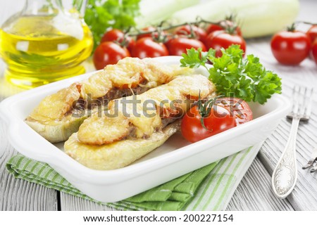 Zucchini with meat, tomatoes and cheese on the table