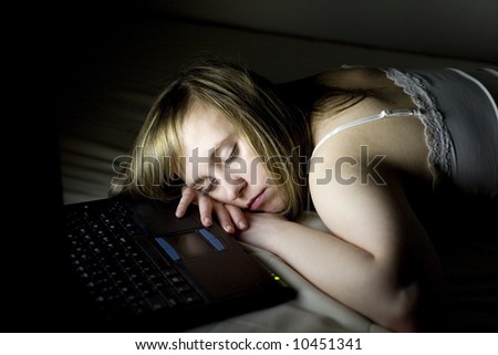 Young woman takes a break and sleeps on the couch, front of her laptop
