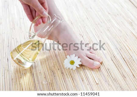 Foot care -Spa and wellness scene - Feet and oil on the bamboo mat