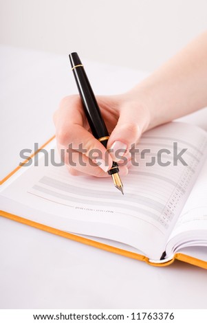 Female hand with the pen/ calendar