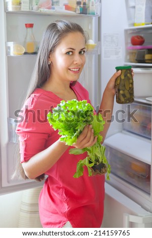 pregnant young woman at an open fridge