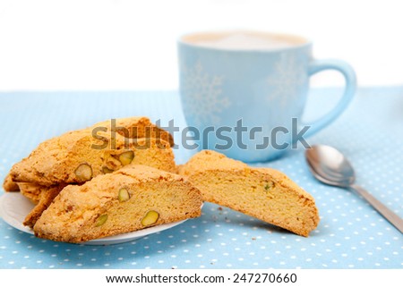 The big cup of hot beverage with cookies on blue tablecloth