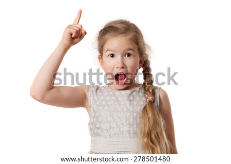 Portrait of excited young girl pointing finger up over white background and looking at camera