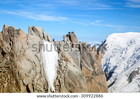 Two alpinists on top of cliff in mountains