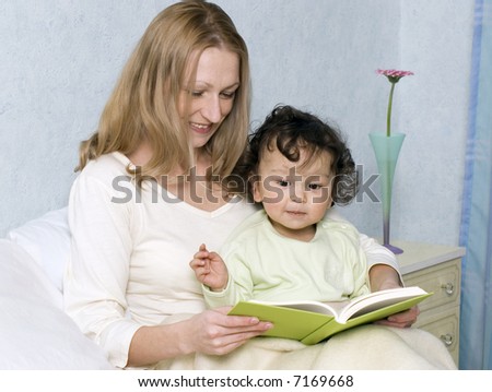 Mother reads to the child the book.