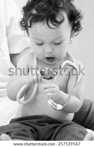 Baby at the doctor, looks at a stethoscope
