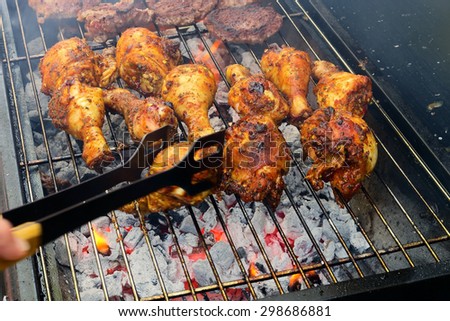 The concept of sunny summer days with Golden drumsticks & sizzling burgers cooking on the Barbecue / Chicken on the BBQ
