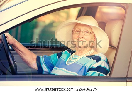 senior lady in glasses driving automobile