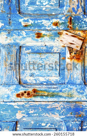 blue stripped paint in the wood door and rusty nail