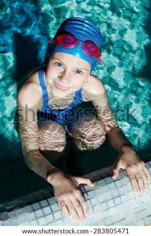 Swimmer preparing to swim on his back. Holding of competitions in swimming. Girl preparing to start. The girl looks into the camera.