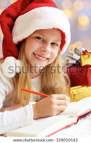 Portrait of little girl with Christmas gifts on the colored background. Christmas dreams.