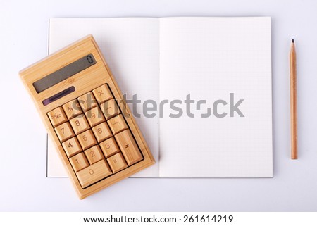 open blank notebook with wooden pencil and calculating machine, business concept