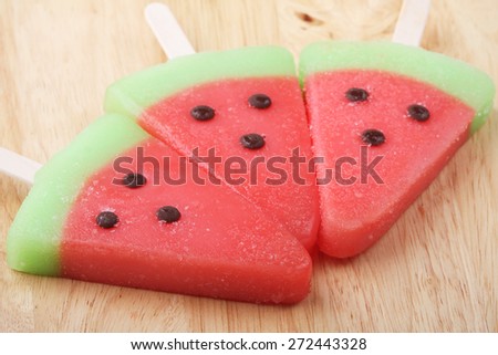 watermelon shaped ice cream pops line on wooden plate