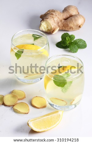 refreshing flavors of lemonade, ginger, and mint in a glass on white marble top table
